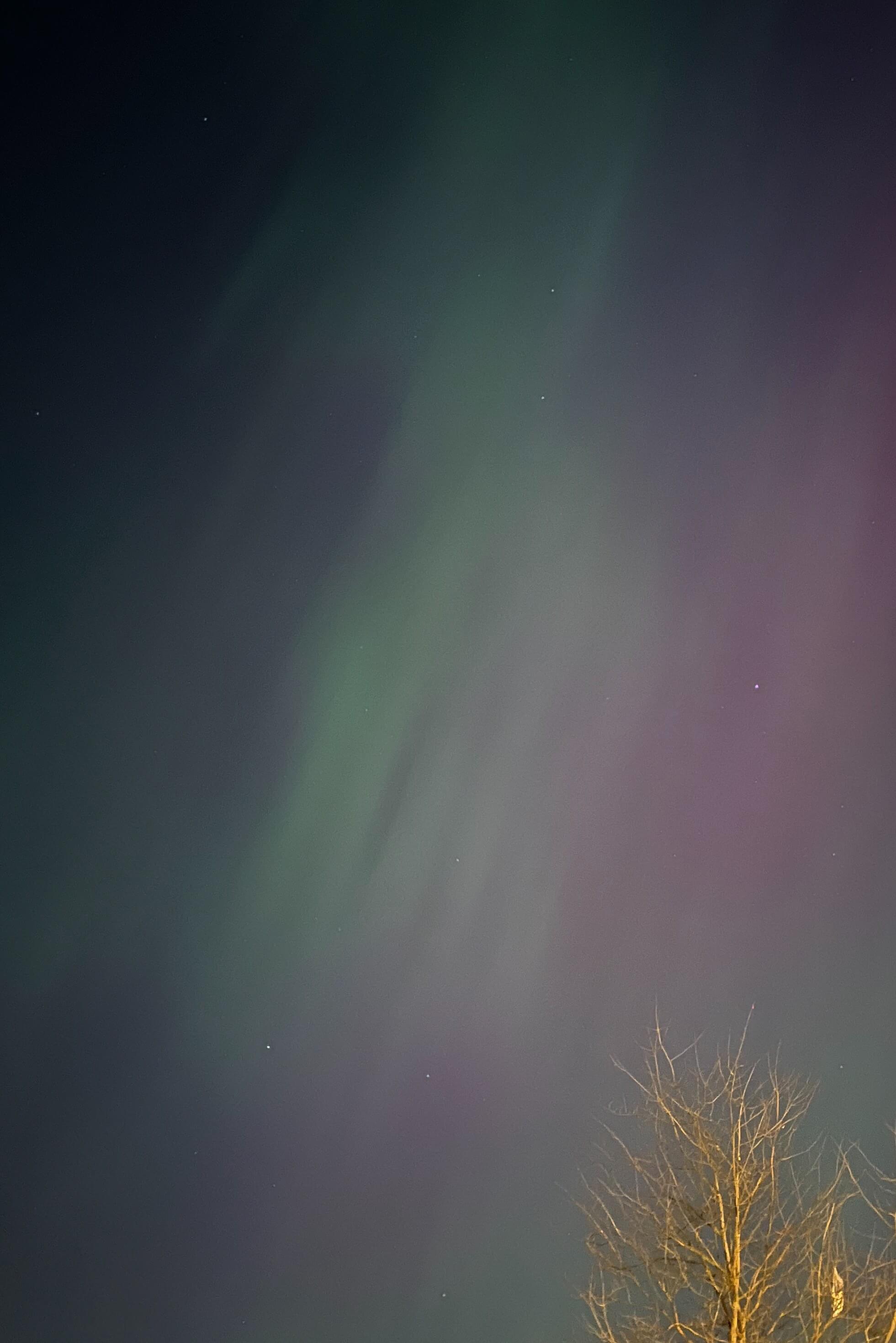 Faint streaky northern lights: a pale green and barely visible pink.