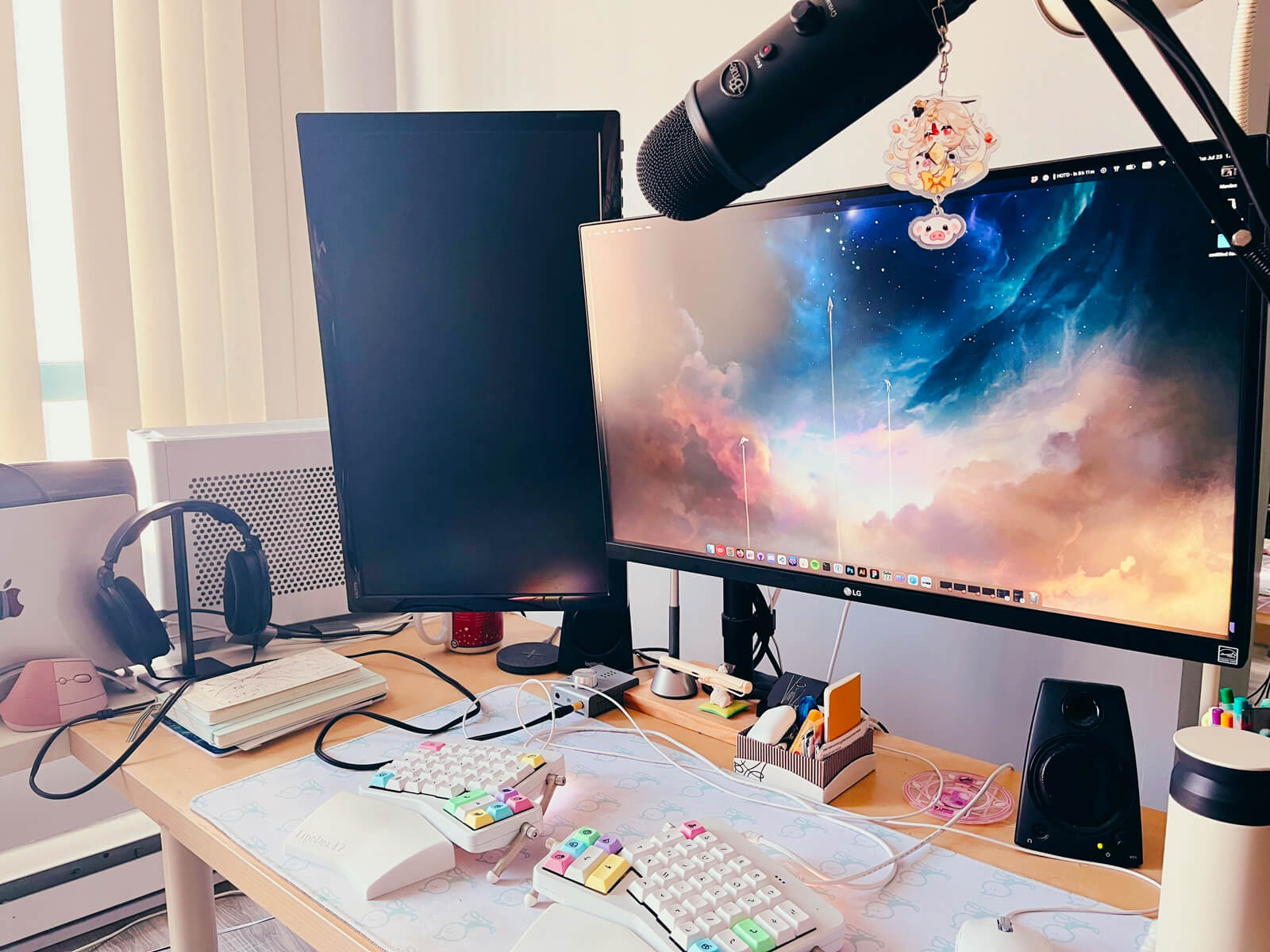 My computer desk setup, featuring two monitors, an ergonomic keyboard, and an abundance of messy cables everywhere. To the side are a docked Macbook and a PC.