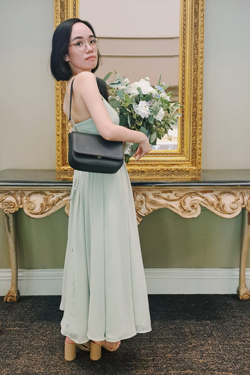 Me holding a bouquet of flowers and wearing a pale green dress.