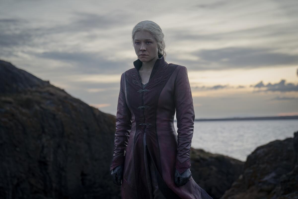 Rhaenyra Targaryen looking off into the distance. Behind her is a wide open sea.