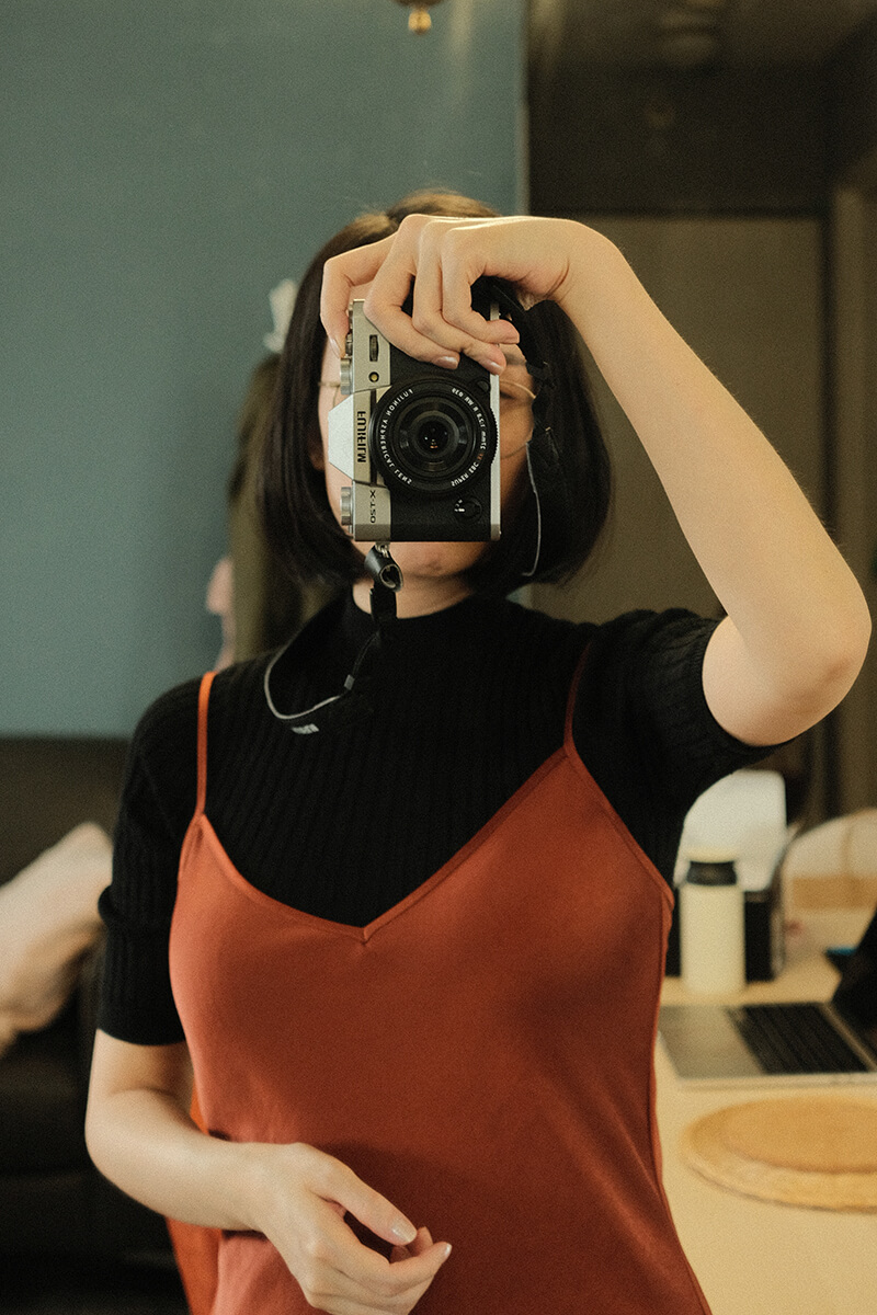 Indoor mirror selfie where I’m holding a mirrorless camera up to my face.