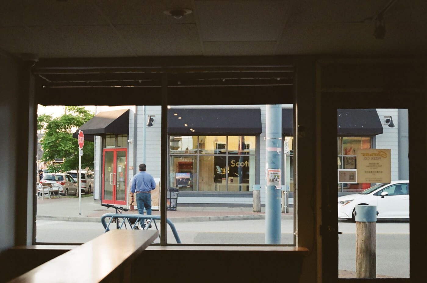 Looking out the window from inside a dark restaurant.