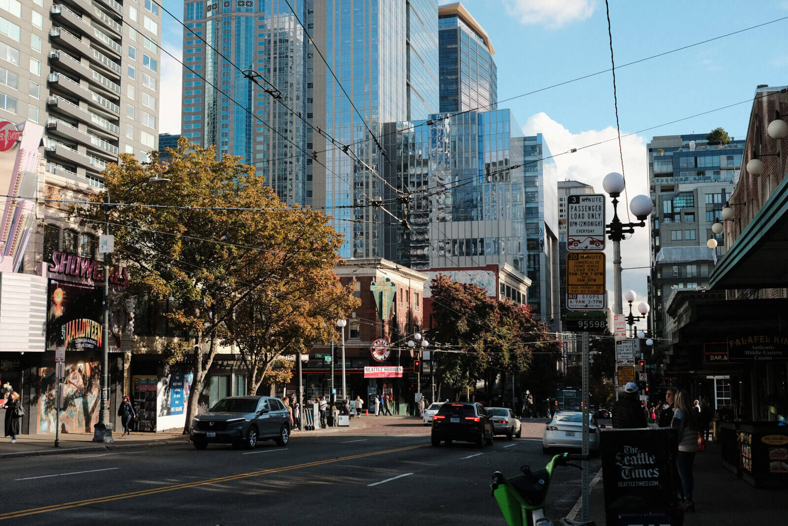 Street view of Seattle, where tall glassy buildings loom overhead and many pedestrians fill the sidewalks.