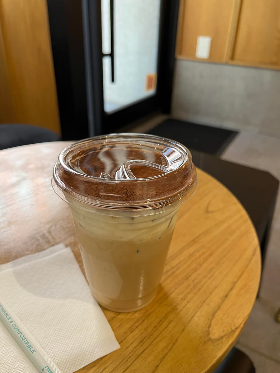 A tiramisu iced latte, which appears to have a layer of cream and chocolate powder on top.