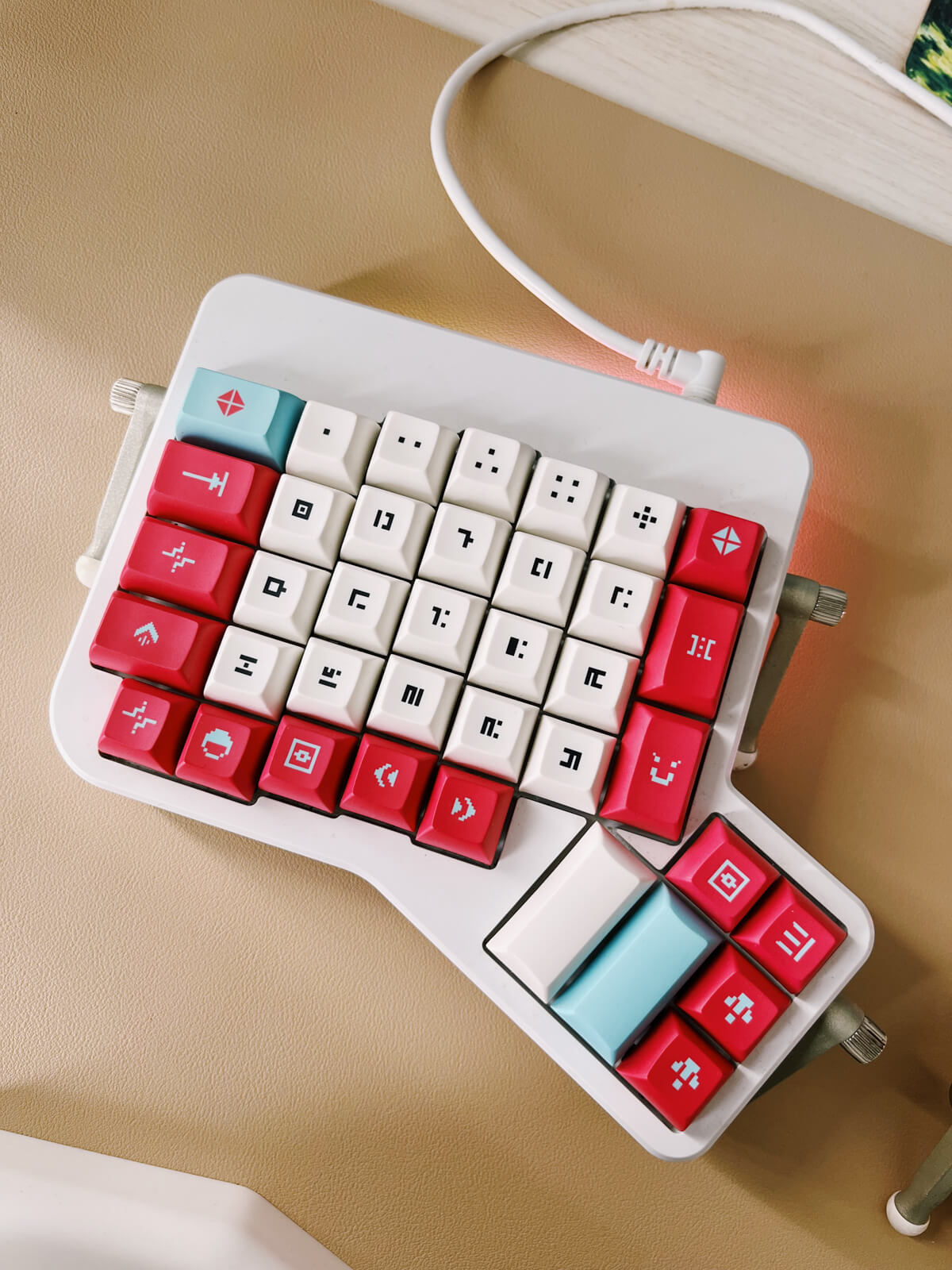 Closeup of keyboard (left side). The keycaps have white alphas, and red and blue mods. The legends are symbols rather than actual Latin characters.