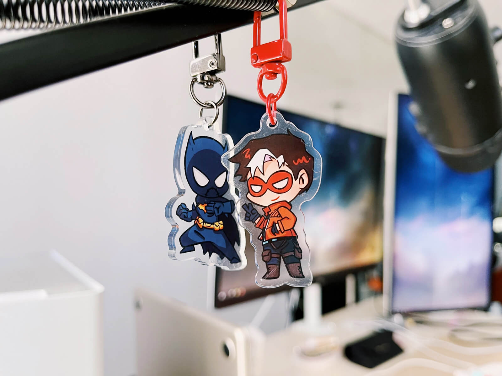 Acrylic charms of Black Bat and Jason Todd hanging from my microphone mount.