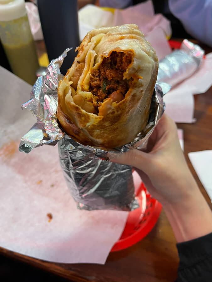 Holding a giant burrito.