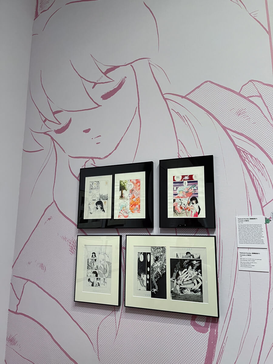 Corner with a large drawing of Inuyasha on the wall, and smaller frames of various manga pages.