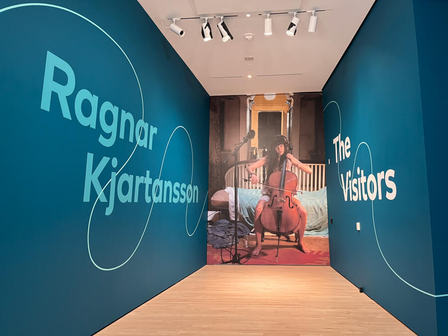 The exhibit entrance, featuring a photo of a cellist which covers the wall.