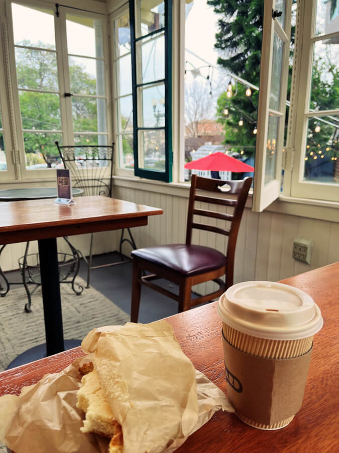 Interior room, lined with windows. On the table is my coffee and half-eaten pastry.