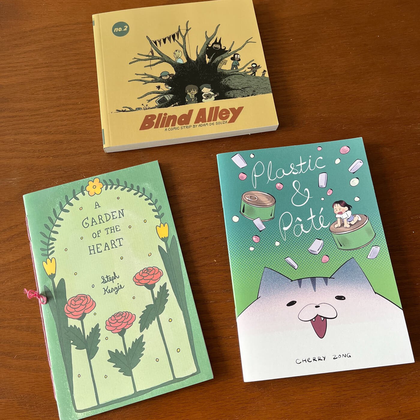 A comic book and two zines on a table.